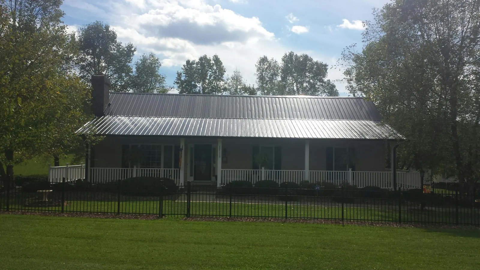 Gray metal roof on a brick ranch with a full width front porch — Gutter Guard Installation work by our crew in Idyllwild